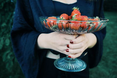 Young woman holding a bowl with strawberries