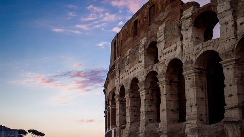 Low angle view of coliseum against sky in city