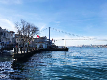 Bridge over river in city against sky