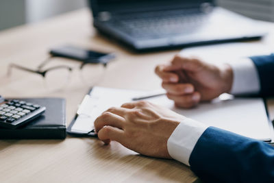 Midsection of man using laptop on table