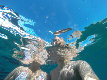 Low angle view of man and woman in sea