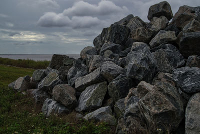 Rock formations on sea shore against sky