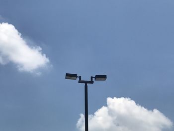 Low angle view of road sign against blue sky