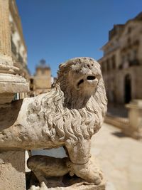 Close-up of statue against historic building