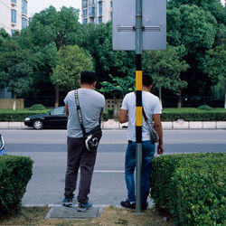 Rear view of people walking on road in city