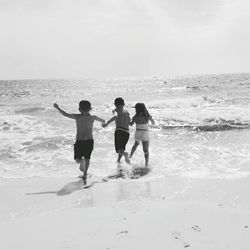 People playing on beach against sky