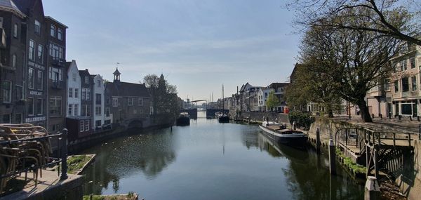 Canal amidst buildings in city against sky