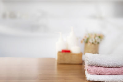 Towels on wooden top table with copy space on blurred bathroom b