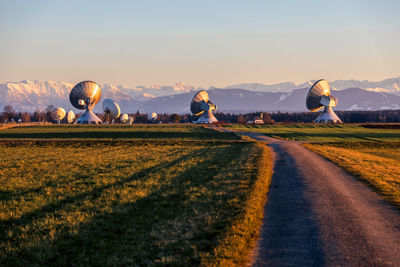 Huge parabolic antenna on a field with mountain view 