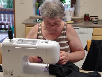 Close-up of woman using sewing machine