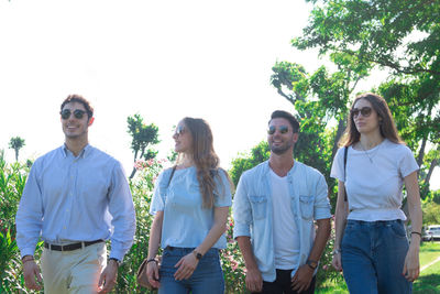 Young men standing against plants