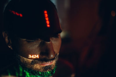 Close-up portrait of man looking at illuminated camera