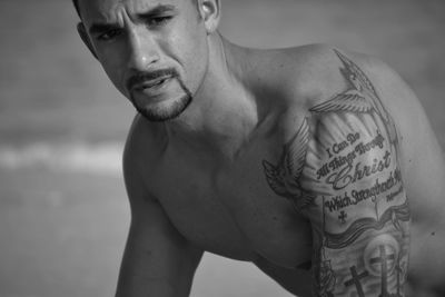 Close-up of shirtless man with tattoo