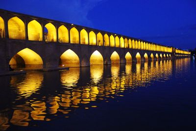 Arch bridge over river against sky