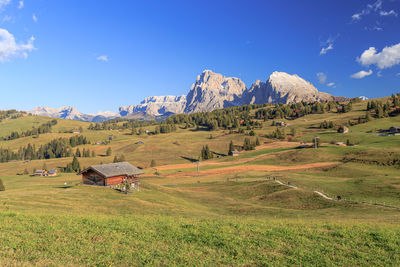 Scenic view of field and mountains against blue sky