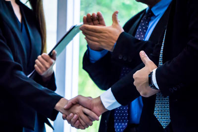 Midsection of business people handshaking