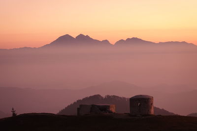Scenic view of silhouette mountains against orange sky