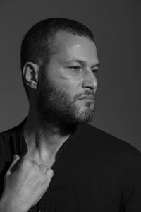 Close-up man looking away against gray background