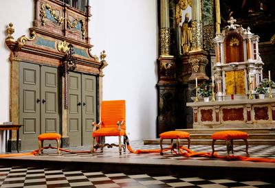 Empty chairs and tables against building