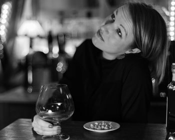 Close-up of mid adult woman holding wineglass in restaurant