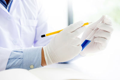 Close-up of man working on white surface