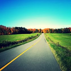 Empty road along countryside landscape