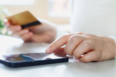 Cropped hands of woman using mobile phone