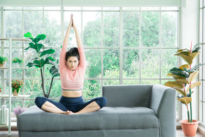 Full length of woman sitting by window