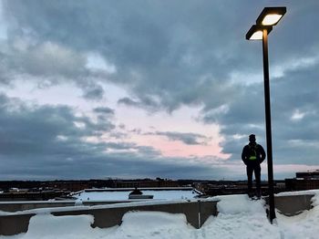 Man standing on snow against sky during sunset