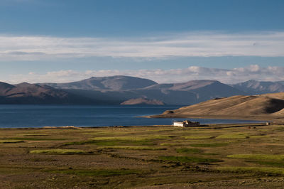 Scenic view of land and mountains against sky