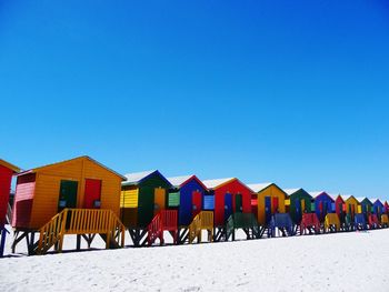 Multi colored chairs on beach against clear blue sky