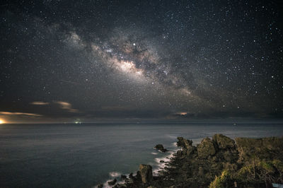 Scenic view of sea against star field at night