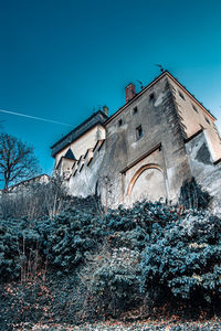 Low angle view of old building against clear blue sky