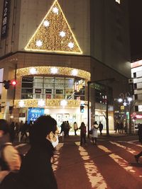 People in illuminated city at night