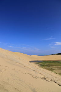 Scenic view of desert against blue sky