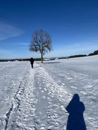 Silhouette person on snow covered field against sky