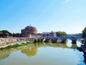 Arch bridge over river against sky
