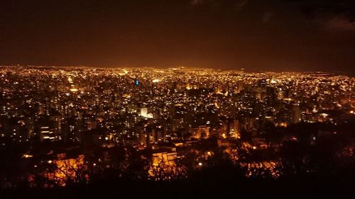 High angle view of illuminated buildings against sky at night