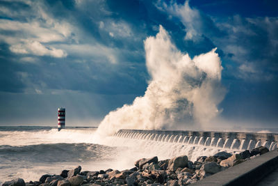 Scenic view of huge wave crashing against breakwater