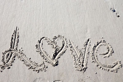 Close-up of text on sand