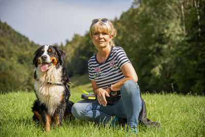 Woman with dog sitting on grass