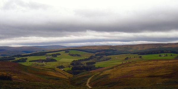 Scenic view of grassy field against cloudy sky