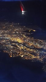 Aerial view of illuminated sea against sky at night