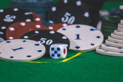 Close-up of gambling chips with dices on table in casino