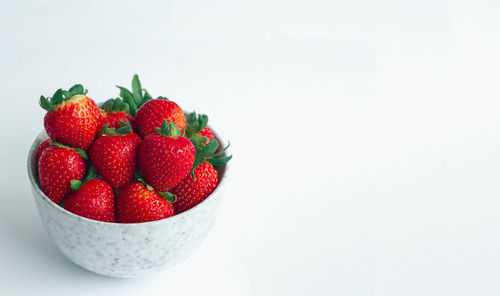 Close-up of strawberries in bowl against white background