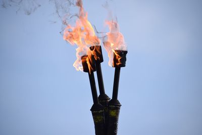 Close-up of flaming torch against clear sky