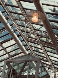 Low angle view of hand holding illuminated ceiling