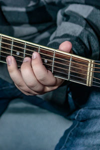 Cropped hand of person playing guitar