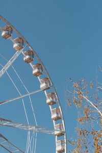 Low angle view of ferris wheel against clear blue sky