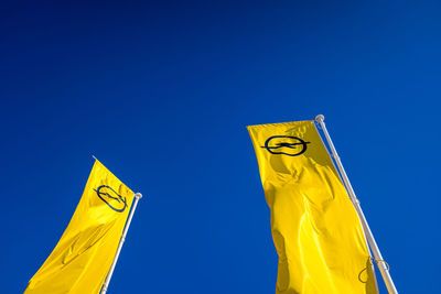 Low angle view of flag against blue sky